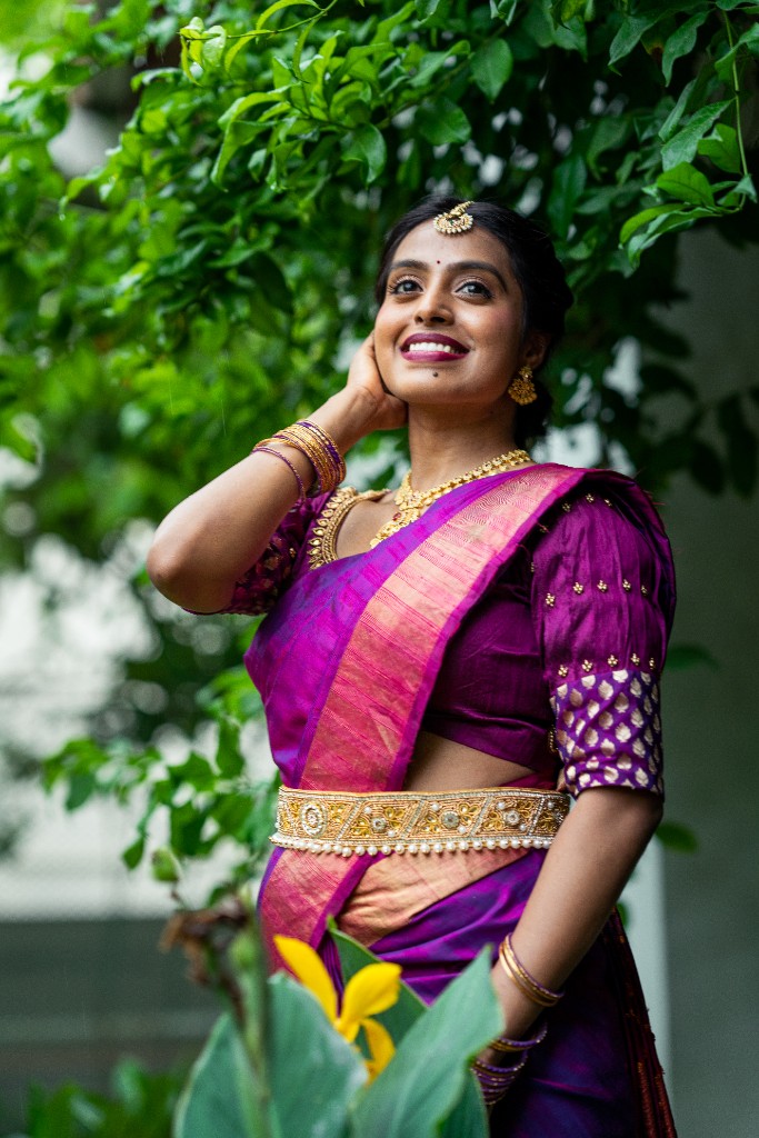 Swetha smiling in purple saree